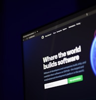 A computer screen displays a website with the text 'Where the world builds software' prominently featured. Below the text, there are fields for users to input their email address, along with additional descriptions about the platform and its capabilities. The website has a dark background with bright text, indicating a professional tech-based service.